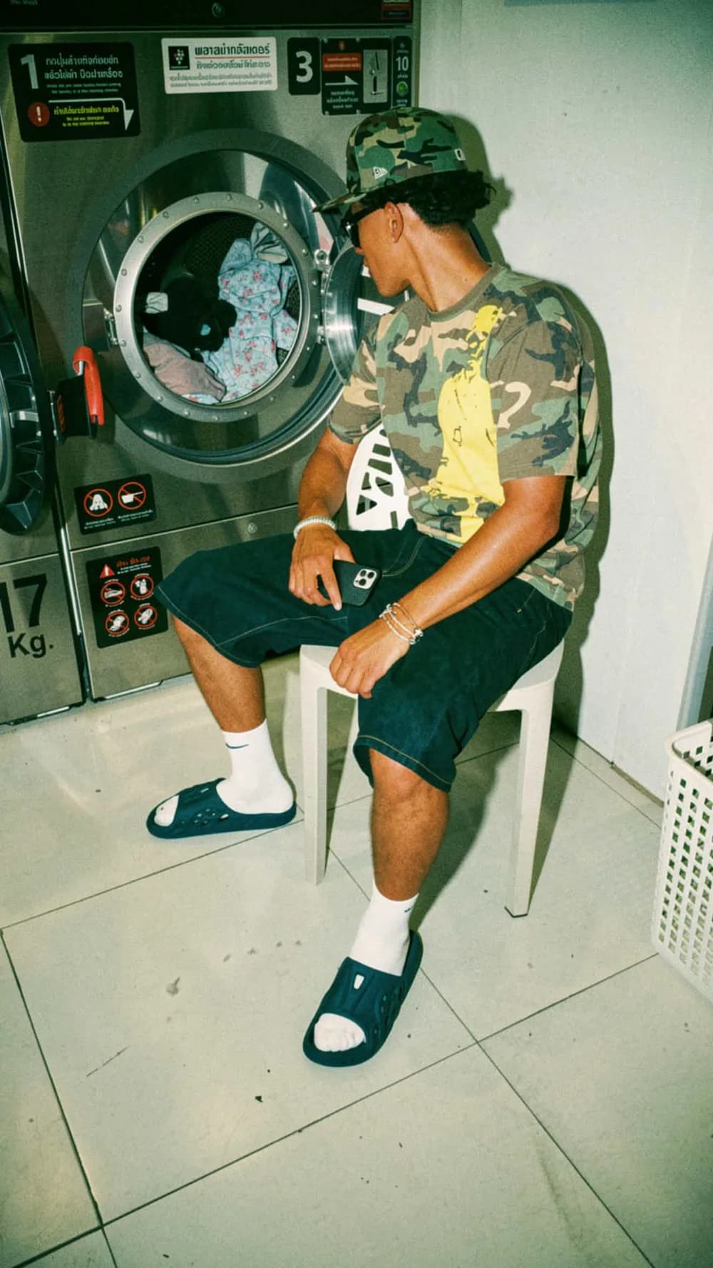 Guy in the camouflage t-shirt sitting in a laundromat
