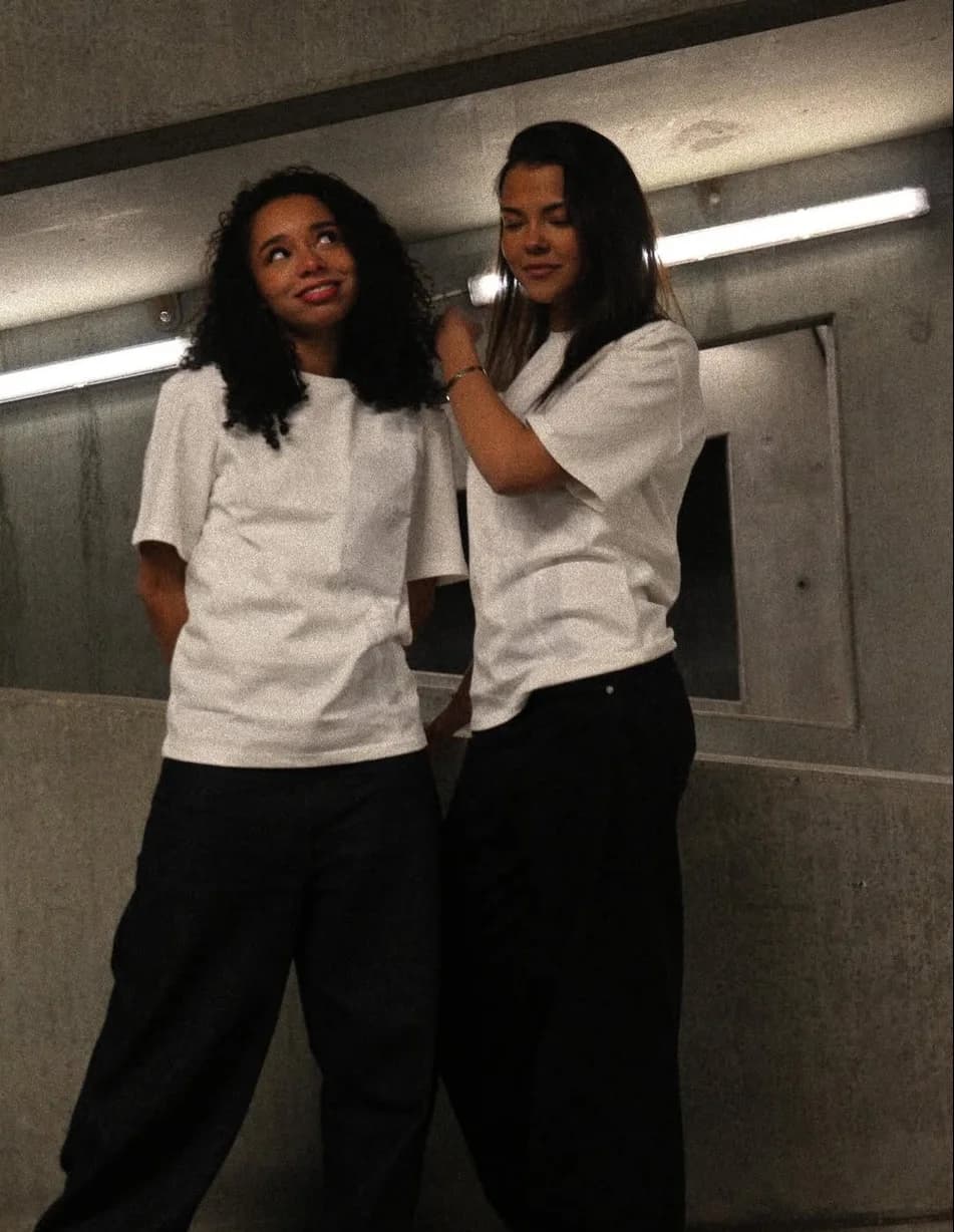 Two girls in white t-shirts in a concrete underpass